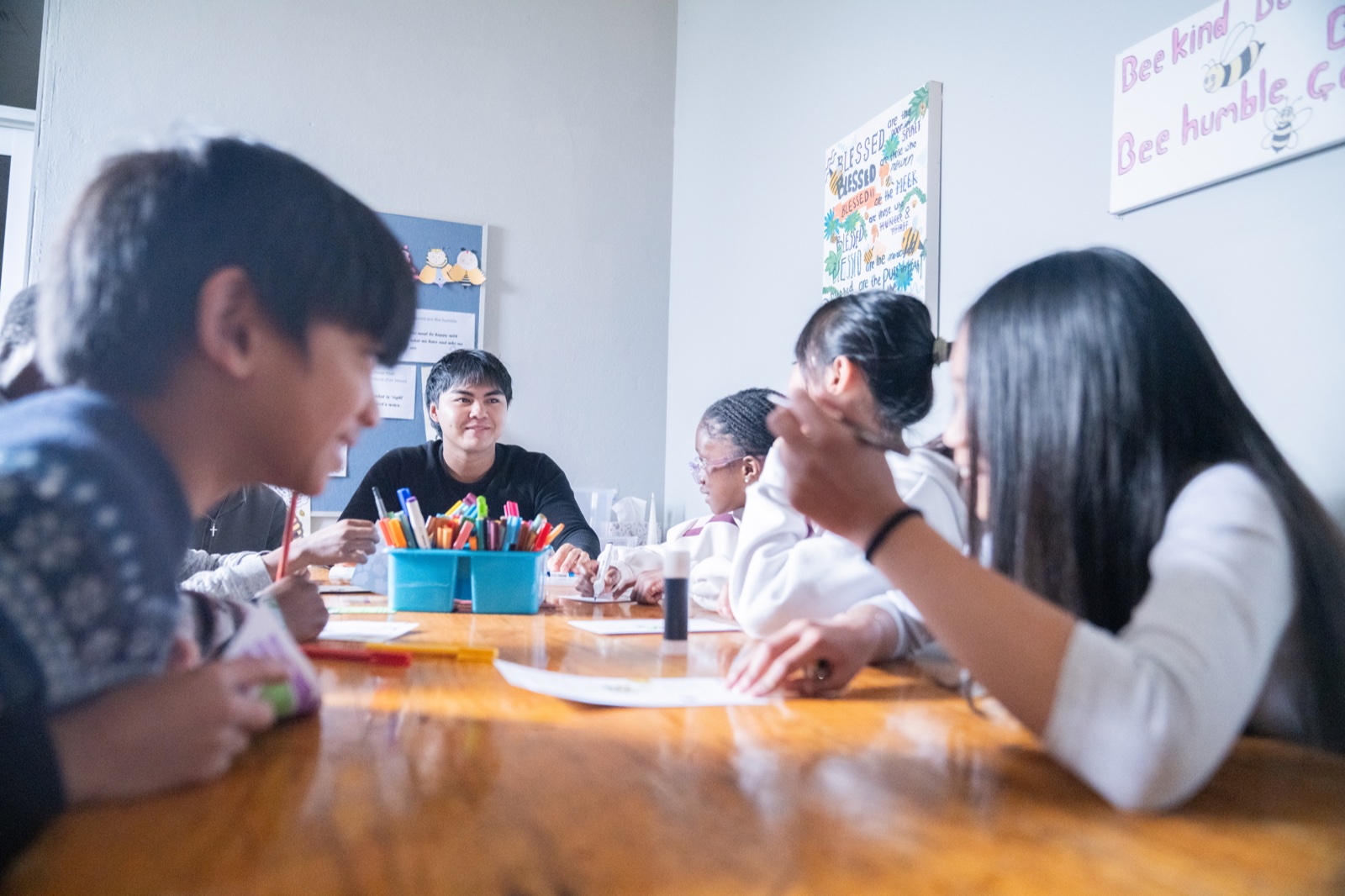 Older children gathered around a table at Cornerstone Crew